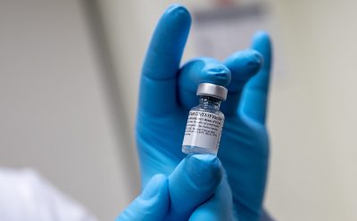 scientist holds a vial of the pfizer-biontech covid-19 vaccine