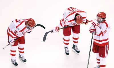 Freshmen Chase Phelps (12) and John MacLeod (16) hang their heads following BU's 4-3 loss to Providence College in the NCAA title game. Sophomore Robbie Baillargeon (19) looks on. PHOTO BY MAYA DEVEREAUX/DAILY FREE PRESS 