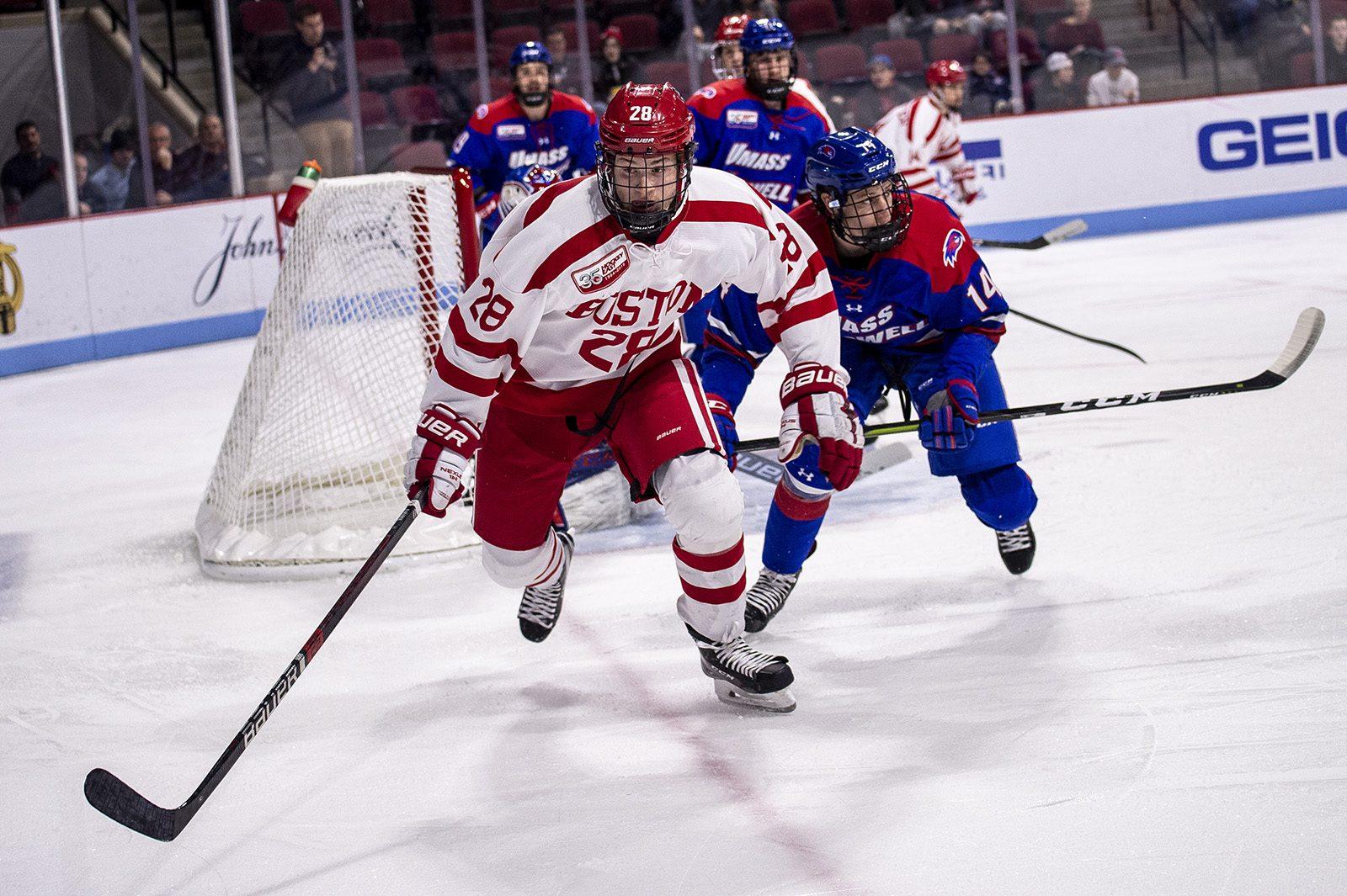 Freshman forward Joel Farabee attempts to beat UMass Lowell forward Reid Stefanson to the puck during the third period. PHOTO BY MADDIE MALHOTRA/ DAILY FREE PRESS STAFF