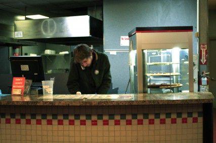 Domenic Bucci, 23, of Allston, answers the phone at Giga’s Pizza on Buswell Street Tuesday. PHOTO BY SARAH FISHER/DAILY FREE PRESS