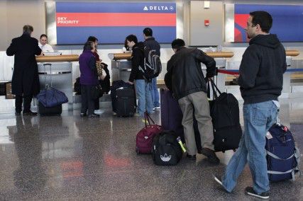 Sequester cuts could impact overall efficiency at Logan Airport. Customers lined up at the Delta Airlines check-in counter at Logan Tuesday afternoon. PHOTO BY KIERA BLESSING/DAILY FREE PRESS STAFF