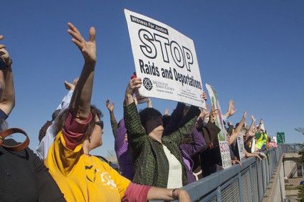 Sarah Richards of Somerville, who graduated from and taught at Boston University, holds a sign as protesters wave at inmates Sunday afternoon, at the Suffolk County House of Corrections, during a protest organized by the Boston New Sanctuary Movement. PHOTO BY SARAH FISHER/DAILY FREE PRESS STAFF