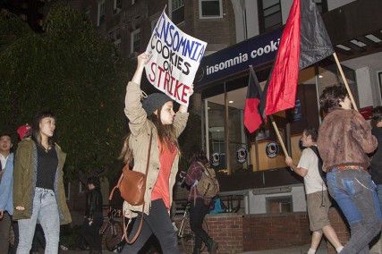 College of Communication junior Lindsay Kopit holds a sign during a protest against Insomnia Cookies Friday night in front of the Insomnia Cookies shop on Commonwealth Avenue. PHOTO BY SARAH FISHER/DAILY FREE PRESS STAFF