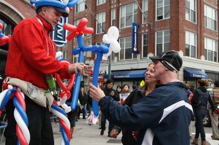 David Forance and Jennifer Langille, dressed in Red Sox gear, get red and blue balloons Friday afternoon in Kenmore Square. PHOTO BY MAYA DEVEREAUX/DAILY FREE PRESS STAFF