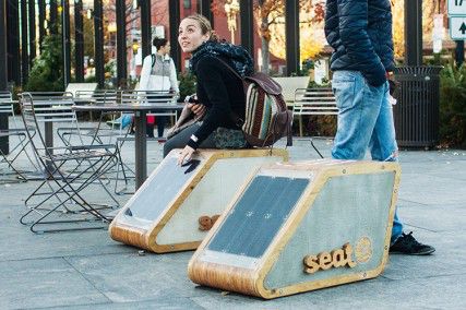 A woman sits on one of the new “seat-e” chairs placed by the city of Boston in the North End on Tuesday. PHOTO BY MADELEINE ATKINSON/DAILY FREE PRESS STAFF