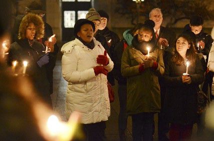 Zoliswa Mali (center), a professor in the BU African Studies Department, leads the crowd in the singing of the South African national anthem Monday night at Nelson Mandela candlelight vigil at Marsh Plaza. PHOTO BY MIKE DESOCIO/DAILY FREE PRESS STAFF