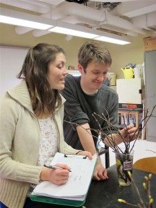 Graduate School of Arts and Sciences student Amanda Gallinat and 2013 College of Arts and Sciences graduate Peter Everill examine twigs they collected for their tree study in Concord. PHOTO COURTESY OF RICHARD PRIMACK