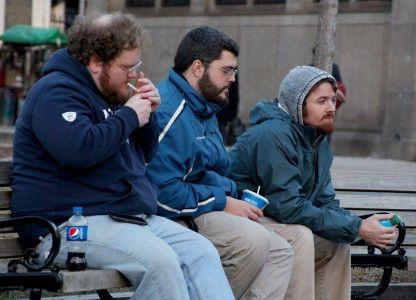 A smoker who prefers to remain anonymous lights his cigarette while sitting in Boston Common. Approximately a dozen people gathered in Boston Common Saturday to protest the city’s smoking ban that Boston Parks and Recreation Commission passed on Dec. 30. PHOTO BY KIERA BLESSING/DAILY FREE PRESS STAFF