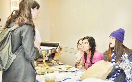 Allie Kulak, College of Communication sophomore, Sara Tabibzadeh, School of Hospitality Administration sophomore and Sasha Engelman, Sargent College of Health and Rehabilitation sophomore, explain the Israeli food their club is serving at the International Food Festival Wednesday night.PHOTO BY LAURA VERKYK/DAILY FREE PRESS STAFF