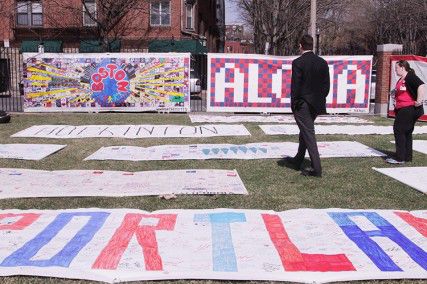 Boston Medical Center held a flag-raising ceremony Monday morning in memory of the victims from the Boston Marathon bombings, featuring Marathon survivor John Odom and portions of the America 4 Boston Prayer Canvas. PHOTO BY MAYA DEVEREAUX/DAILY FREE PRESS STAFF