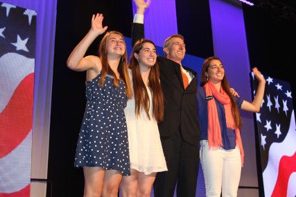 Tom Conroy, candidate for Treasurer, waves to the convention body with three of his four daughters. PHOTO BY FELICIA GANS/DAILY FREE PRESS STAFF