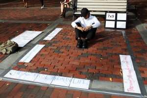 Max Gonzalez (CAS '16) protests solitary confinement by sitting in a 7 feet by 9 feet rectangle, which are similar to the dimensions of a solitary confinement cell. PHOTO BY BETSEY GOLDWASSER/DAILY FREE PRESS STAFF