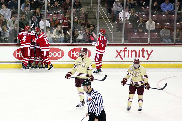 Freshman defenseman Brandon Hickey (4) and freshman forward Nikolas Olsson (13) swarm freshman forward Jack Eichel after his third-period goal. PHOTO BY MAYA DEVEREAUX/DAILY FREE PRESS STAFF