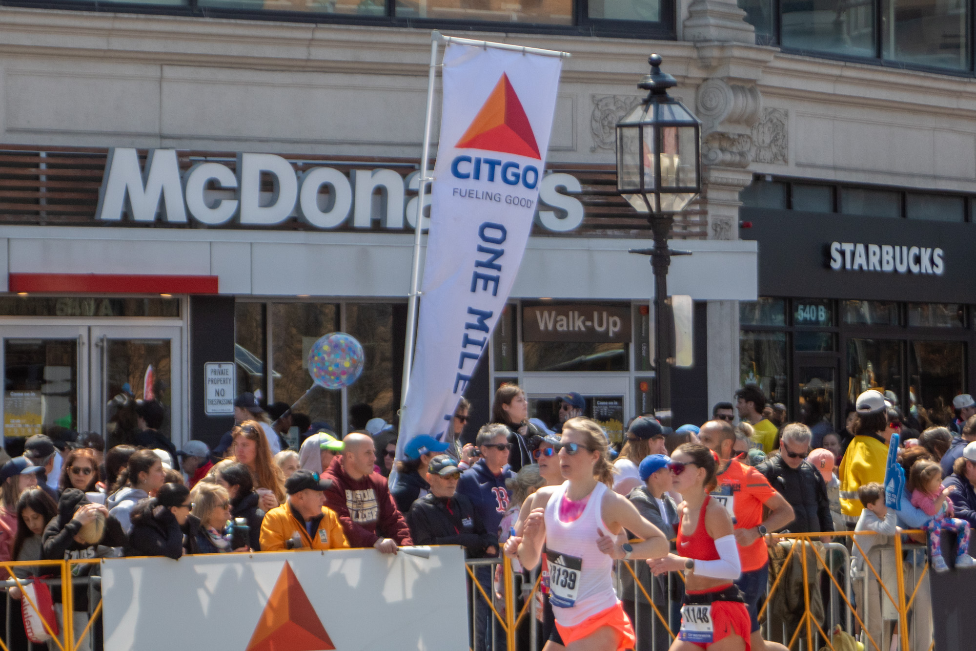 Runners pass by a “one mile to go” sign in Kenmore.