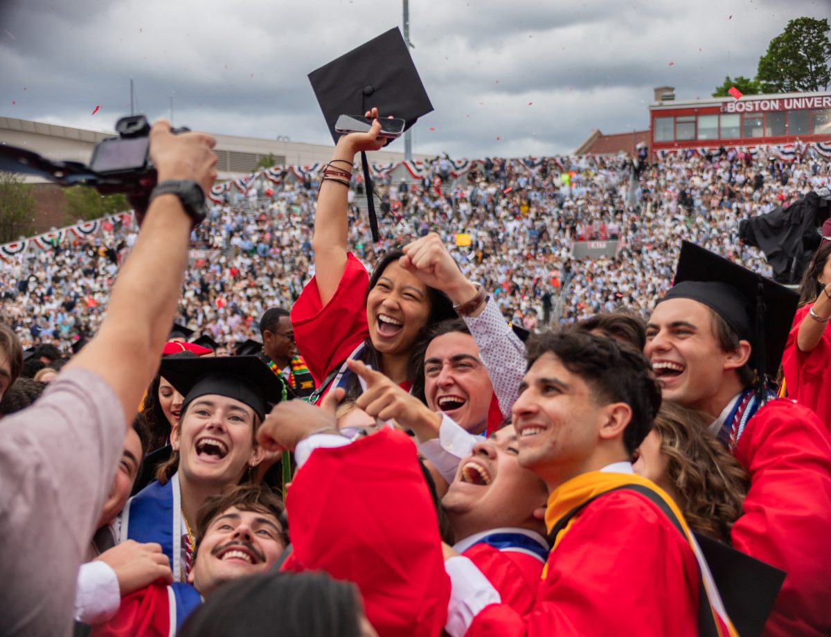Graduates huddle up and cheer for a photo at the end of Commencement. Gilliam concluded her speech with a reminder to the graduates that “once a Terrier, always a Terrier.”