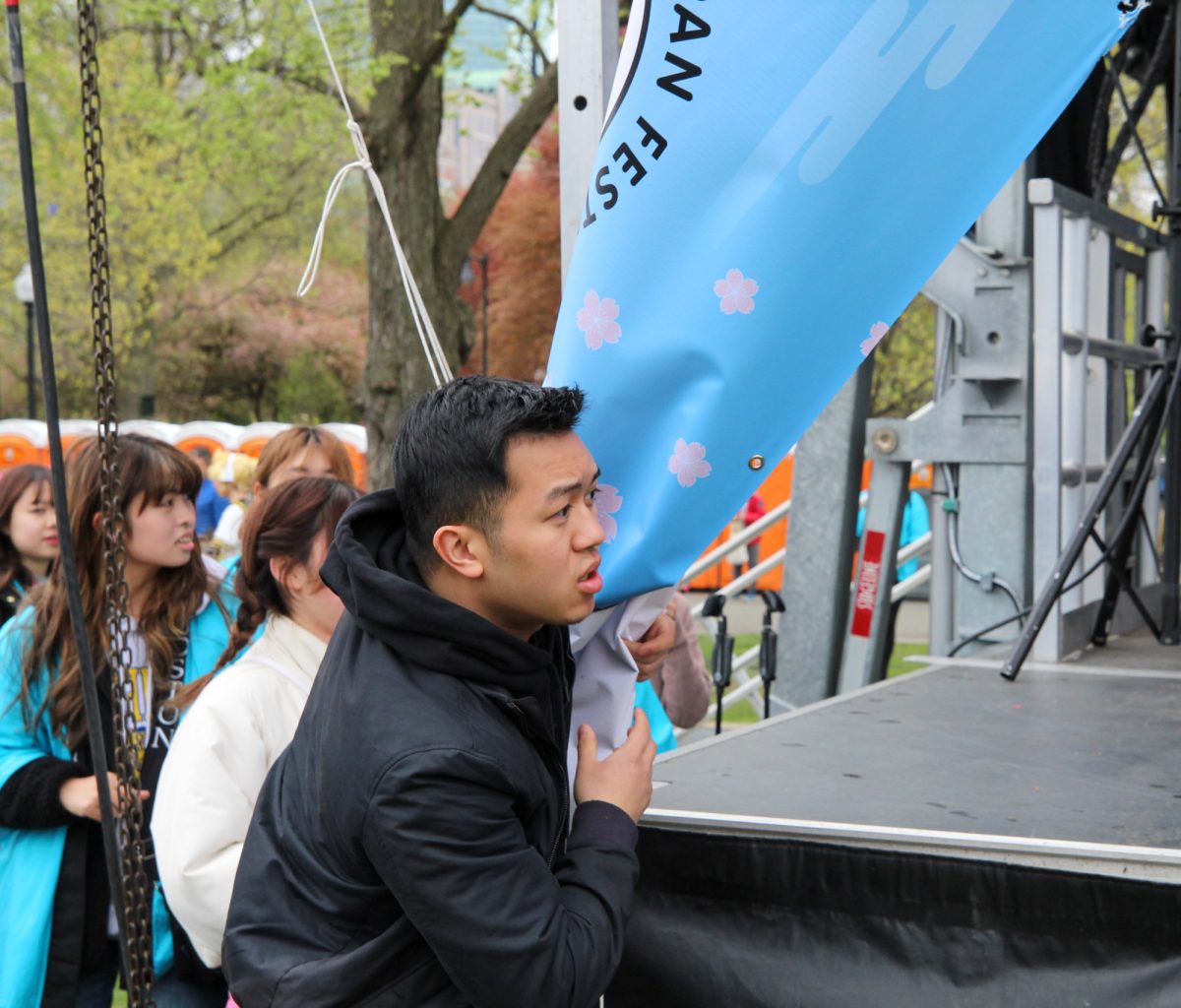 An attendee catches the sign after it detaches due to the wind. 