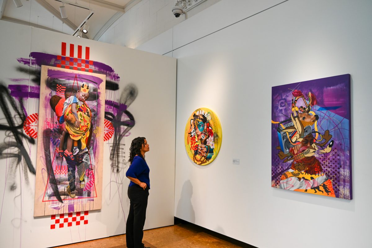 A woman admires several works by featured gallery artist Victor “Marka27” Quiñonez. 
