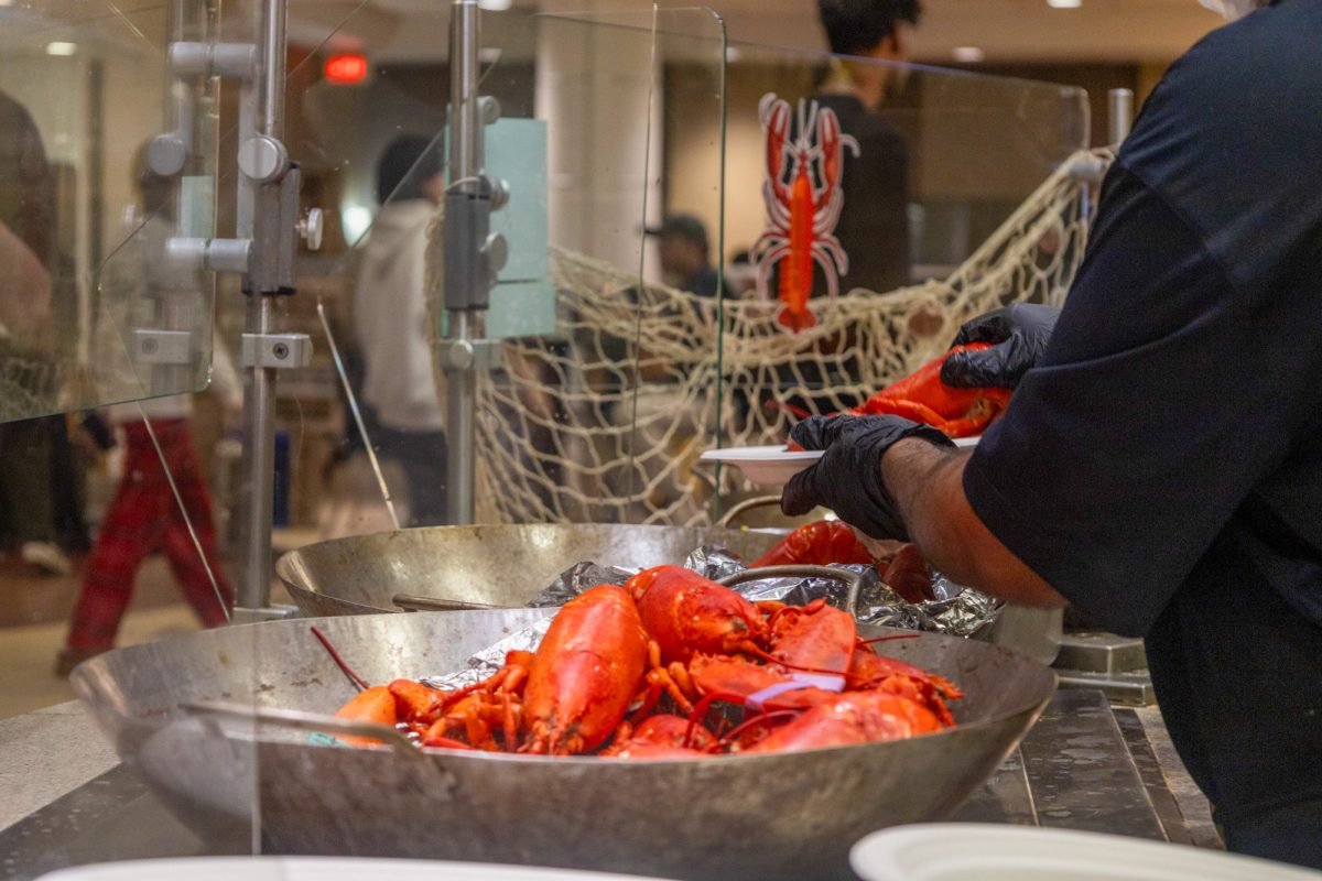 A dining hall employee assembles a lobster plate to serve in the Warren dining hall on Sept. 24th. Warren Dining Hall prepared approximately 2,600 lobsters for this year’s “Lobster Night.”. 