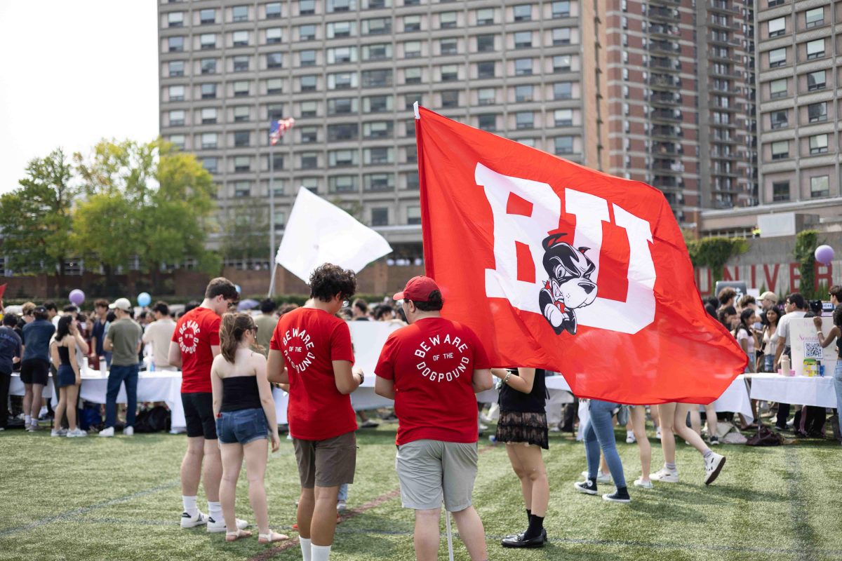 Representatives from the Boston University Dog Pound, which represents BU’s student section at hockey games, wave a BU flag while promoting to students. 
