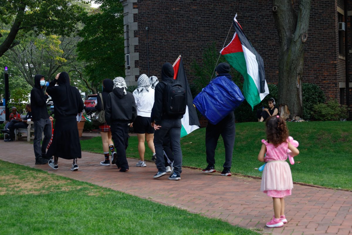 A young girl watching as the Quinobequin Student Front For Palestine walked through an event during Boston University’s alumni weekend.
