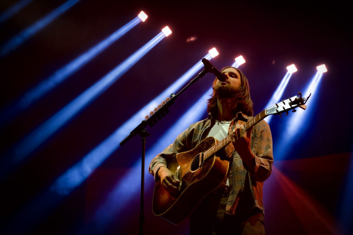 Matt Quinn, lead singer of Mt. Joy. The band performed at TD Garden Sept. 20, with Quinn strumming his acoustic guitar while lights beamed overhead.
