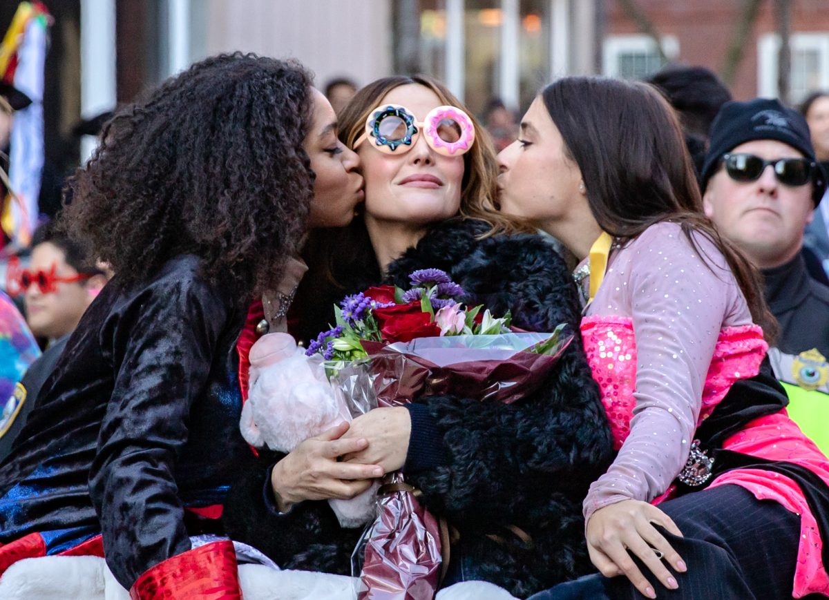 Roasters and “Salooney Tunes” producers Isabel Wilson and Daisy Nussbaum kiss Byrne at the parade’s conclusion on Holyoke Street. 