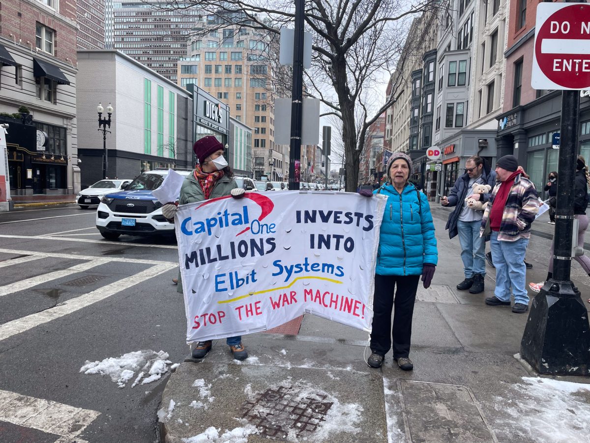 Two protesters hold up a sign in opposition to Capital One’s alleged investment in Elbit Systems. On Saturday, approximately 20 Boycott, Divestment, and Sanctions Boston members gathered outside Capital One Cafe in Back Bay to protest the bank’s alleged $90 million loan to the major defense contractor. PHOTO BY DANIELA GINSBURG