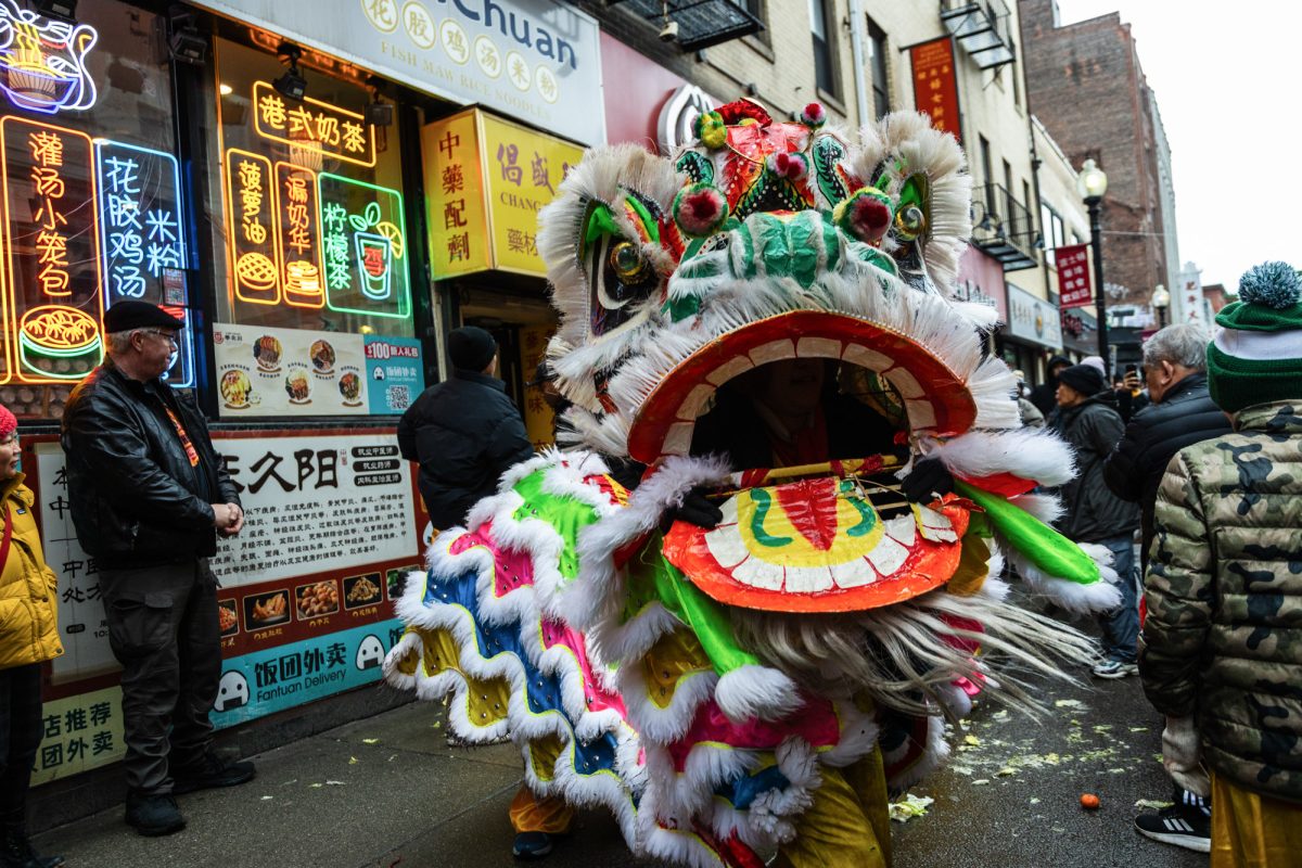 A pair of performers swing their lion’s head.