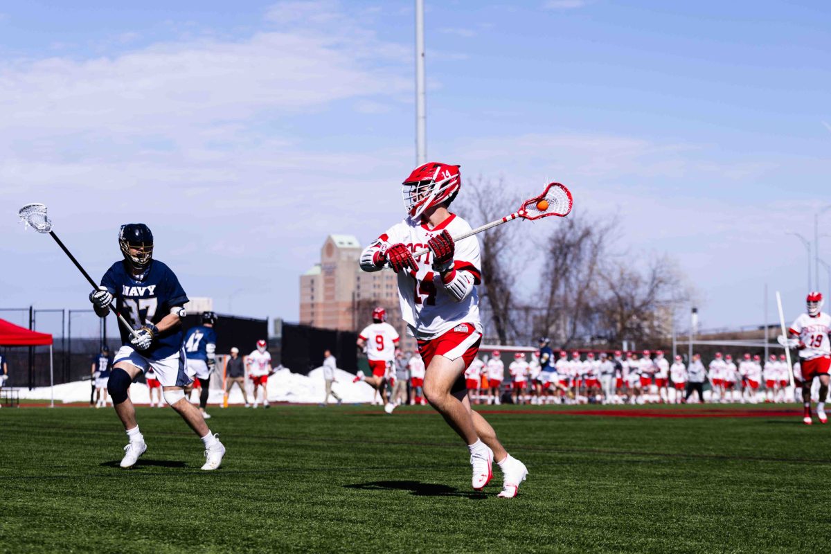 Senior attack Jimmy Kohr (14) passes to an open teammate during a matchup against Navy on Feb. 28. Kohr finished with five goals despite BU men’s lacrosse team losing 19-11 to the Loyola Maryland Greyhounds. 