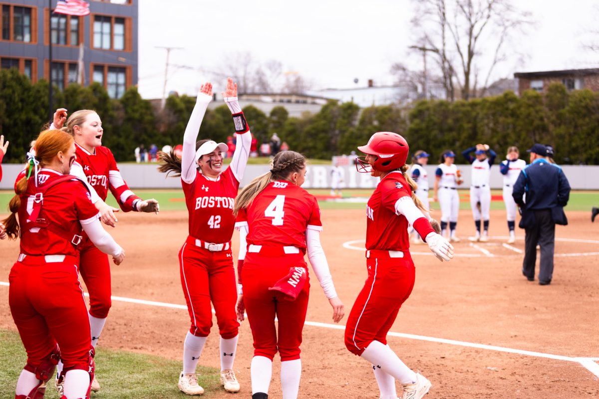 Senior first baseman Megan Coyle (right) celebrates with her teammates after hitting a home run on April 4 against the Bucknell University Bisons. Coyle hit two home runs in the first game of a double header Saturday against the Army Black Knights, where the BU softball team swept both games.