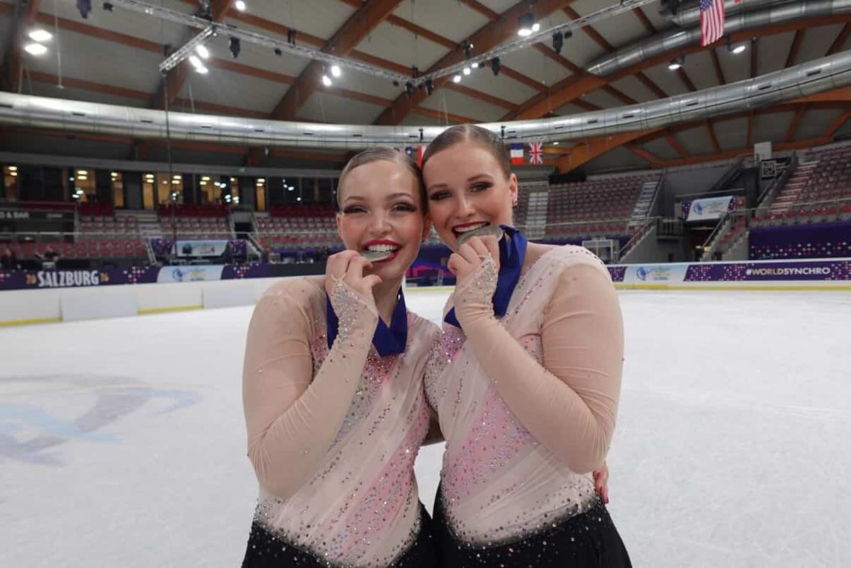 Haydenettes skaters Clara Neal and Caitríona Curry bite their silver medals.