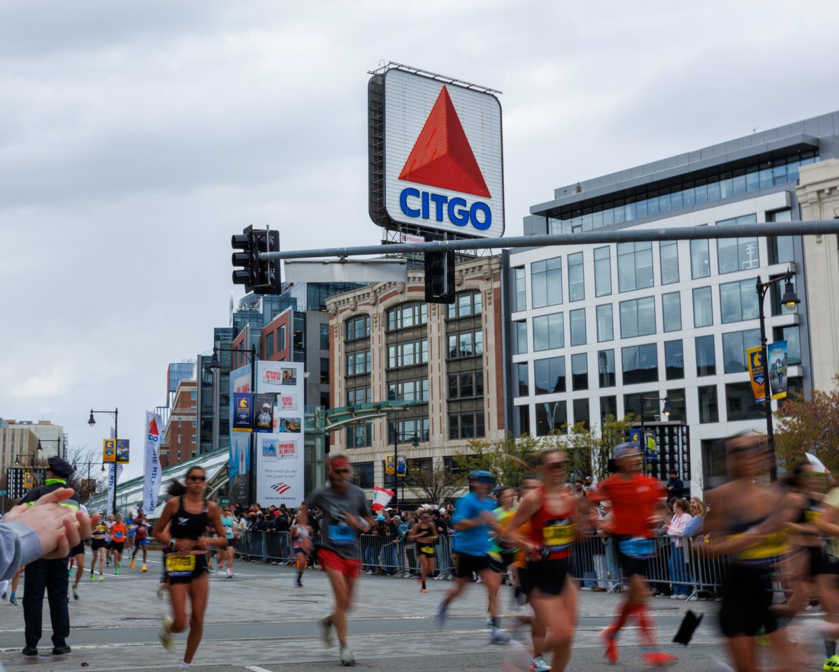 Runners pass through Kenmore Square to cheers from the crowd.
