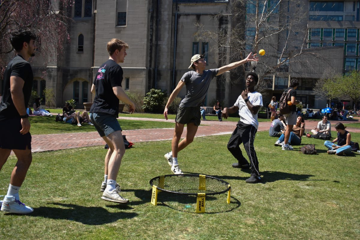 A group of students play spikeball on BU Beach.