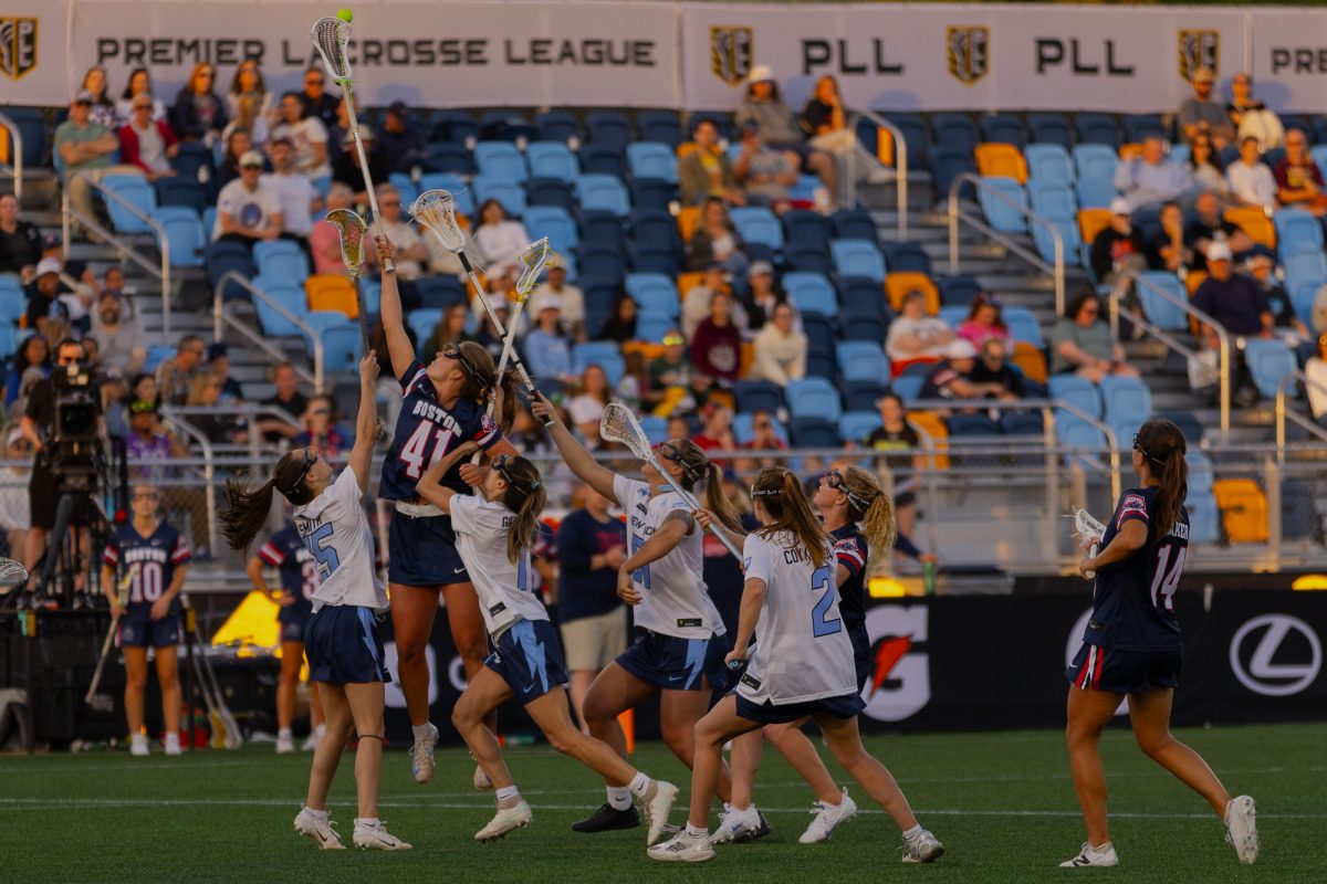 Boston Guard midfielder Kerry Nease (41) jumps above several New York Charging players to win the draw control. 