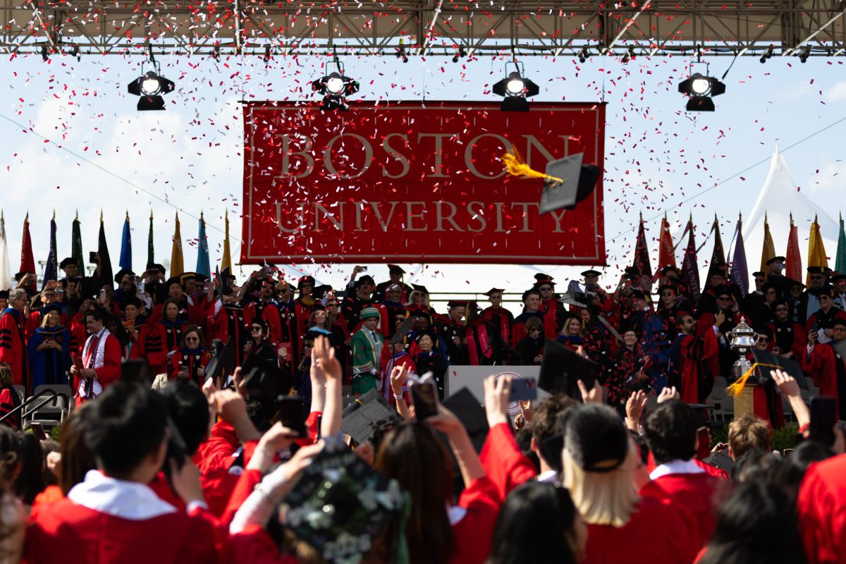 A graduation cap flies through the air as confetti rains down at the end of the ceremony.