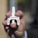 person holding a narcan demonstration device