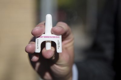 person holding a narcan demonstration device