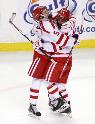 Matt Grzelcyk (left) and Cason Hohmann celebrate Hohmann's first-period goal. PHOTO BY MAYA DEVEREAUX/DAILY FREE PRESS STAFF