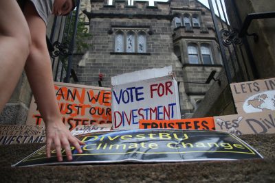 Signs made by members of Divest BU line the stairs up to the BU Castle during a rally in September. PHOTO BY BETSEY GOLDWASSER/ DAILY FREE PRESS STAFF 