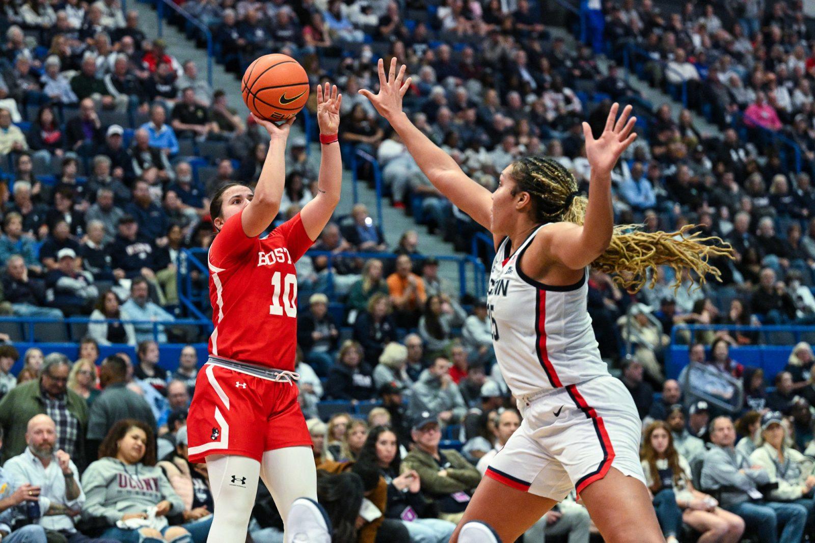 Senior guard Alex Giannaros (10) shoots the ball during an away game against University of Connecticut on Nov. 7. Giannaros has cemented her place among the pantheon of Boston University women’s basketball greats, entering the top 10 career points-scorers in the program. COURTESY OF CLARUS MULTIMEDIA GROUP 
