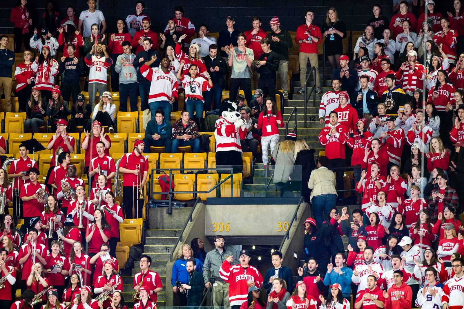 Boston University hockey fans stand up and cheer alongside the BU mascot, Rhett. MADDIE MALHOTRA/ DAILY FREE PRESS 