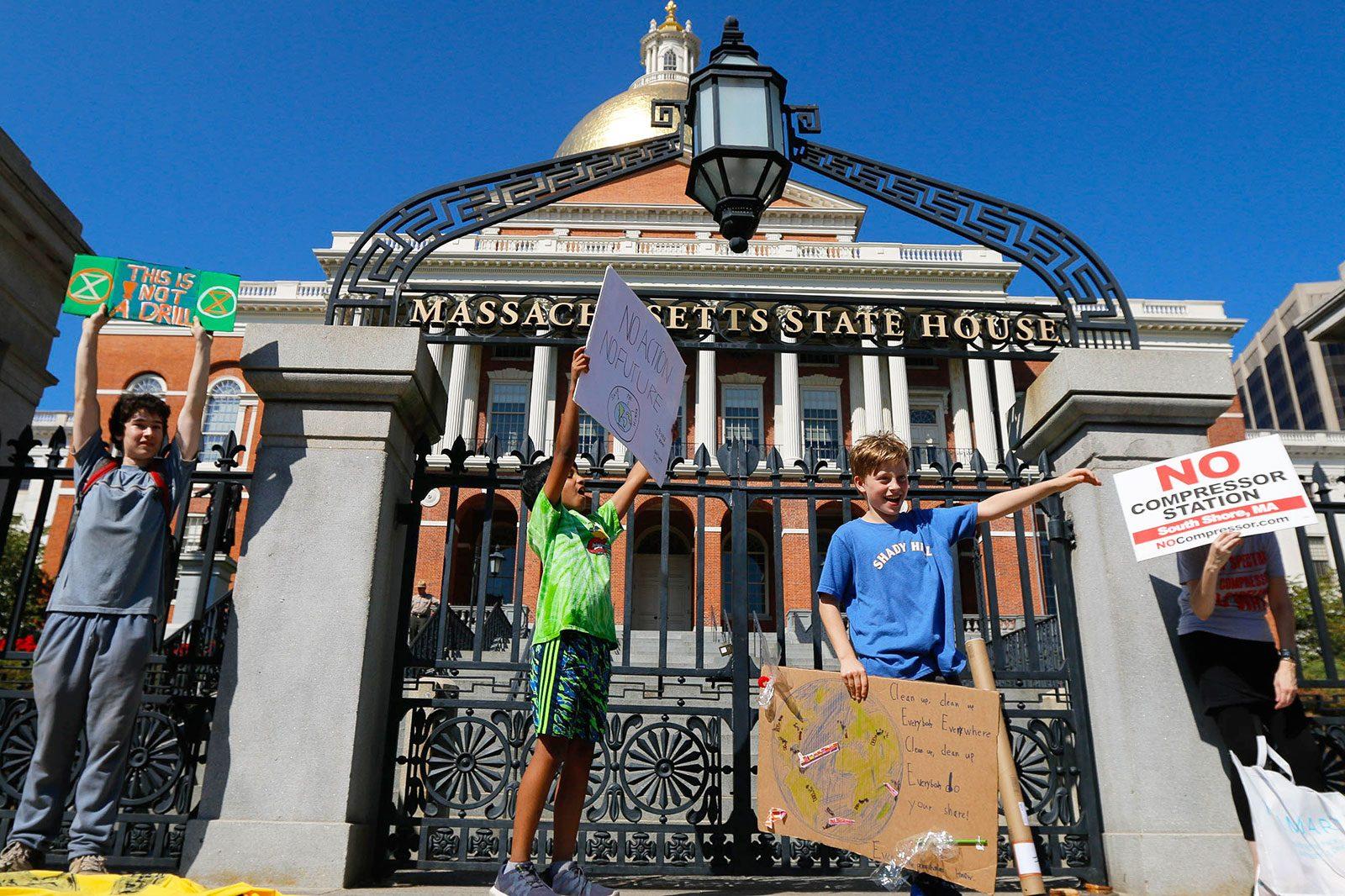 Protestors stand in front of the Boston State House in protest of climate change during the Boston Climate Strike on Sept. 20. Boston Mayor Martin Walsh updated the city’s Climate Action Plan on Tuesday to now include goals to cut back on carbon emissions from buildings. GABRIELA HUTCHINGS/ DFP FILE 