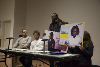 Keith Nolan, a leader for the Multicultural AIDS Coalition, speaks about the group’s advertisements during a Community Service Center panel Friday in the Law Auditorium. PHOTO BY NATLIE CARROLL/ DAILY FREE PRESS STAFF