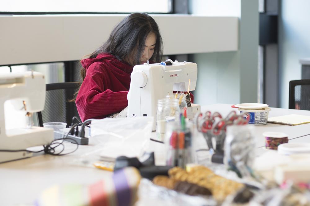 Xiaoyu Yao sews a shirt during “Green Your Wardrobe” over the weekend. The multi-day event was held to help educate people about waste in the fashion industry and show ways to be fashionable in a sustainable way. PHOTO BY DENGFENG YANG/DAILY FREE PRESS STAFF

