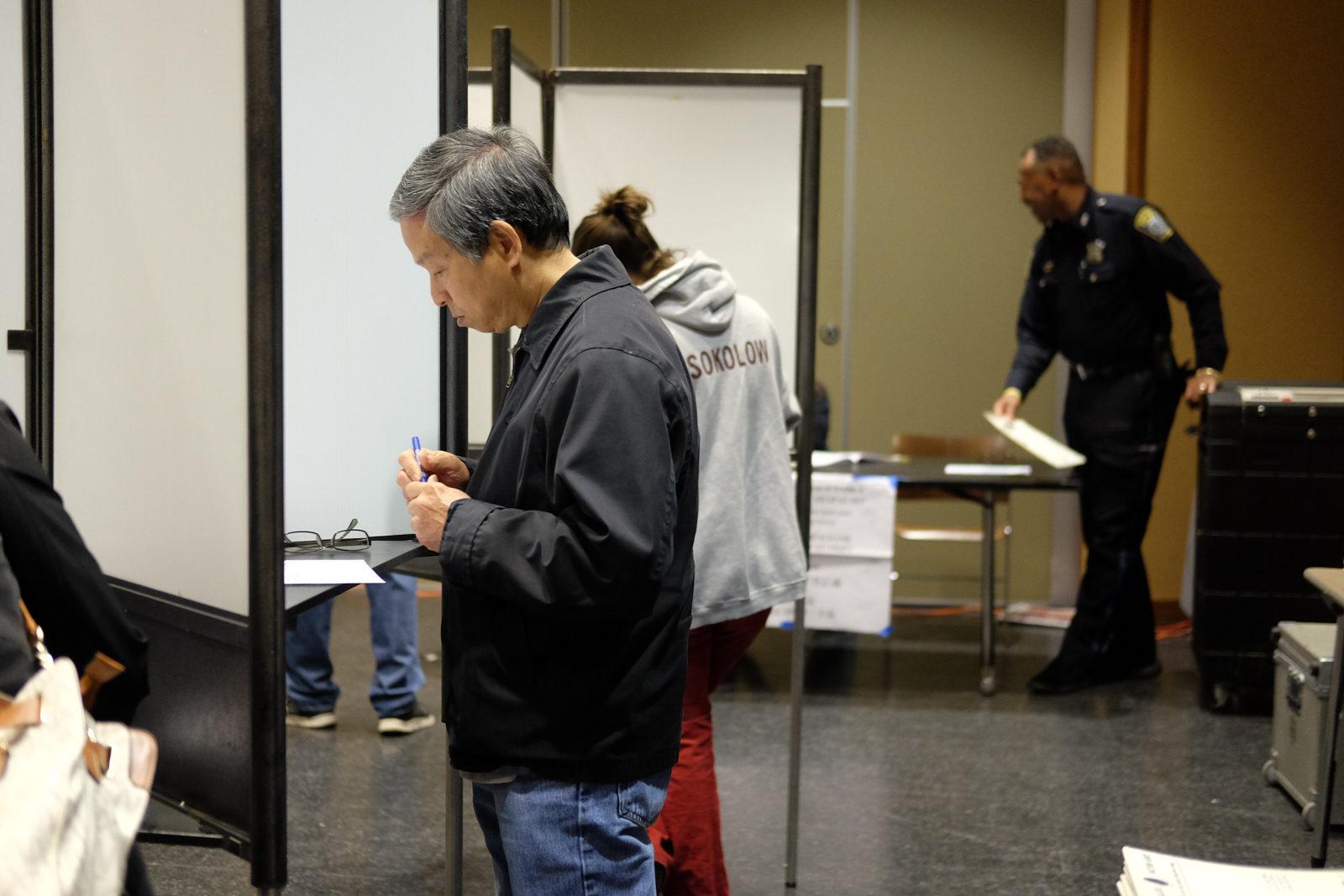 A man votes at the Allston Branch Library. PHOTO BY ISABELLA ARTEAGA/ DAILY FREE PRESS STAFF