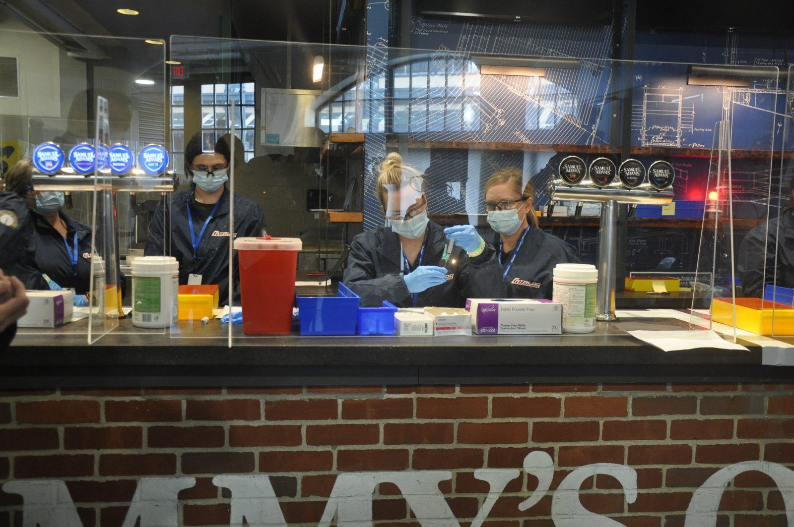 Shots are extracted from Pfizer vials at the Samuel Adams Bar at Fenway. LILY KEPNER/DFP STAFF