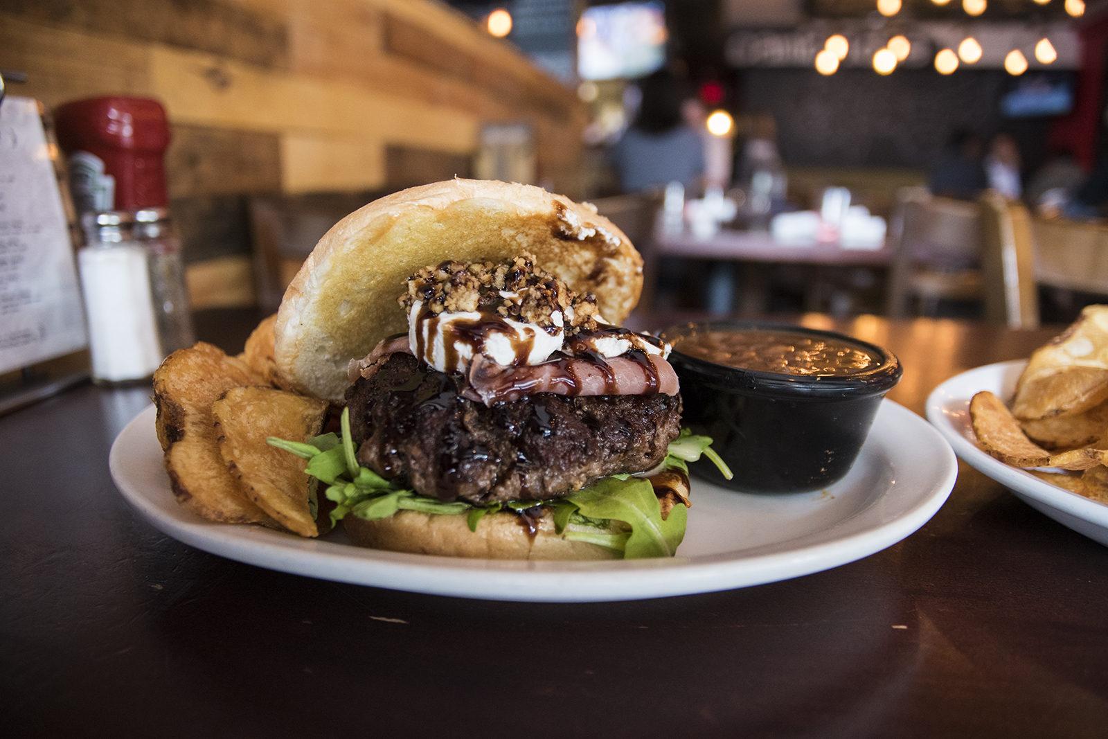 One of Boston Burger Company's prettiest, The Sophie burger, has prosciutto, goat cheese, candied walnuts, fig jam, arugula and a balsamic reduction. PHOTO BY CHLOE GRINBERG/ DAILY FREE PRESS STAFF