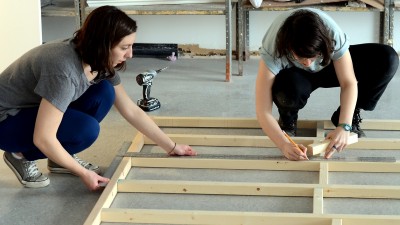 Courtney Teixeira (CFA ‘15) and Sophia Michael (CFA ‘15) build the supports for an experimental art space they are building in the back of a moving truck, which will kick off in Boston Sunday. PHOTO BY DANIEL GUAN/DAILY FREE PRESS STAFF