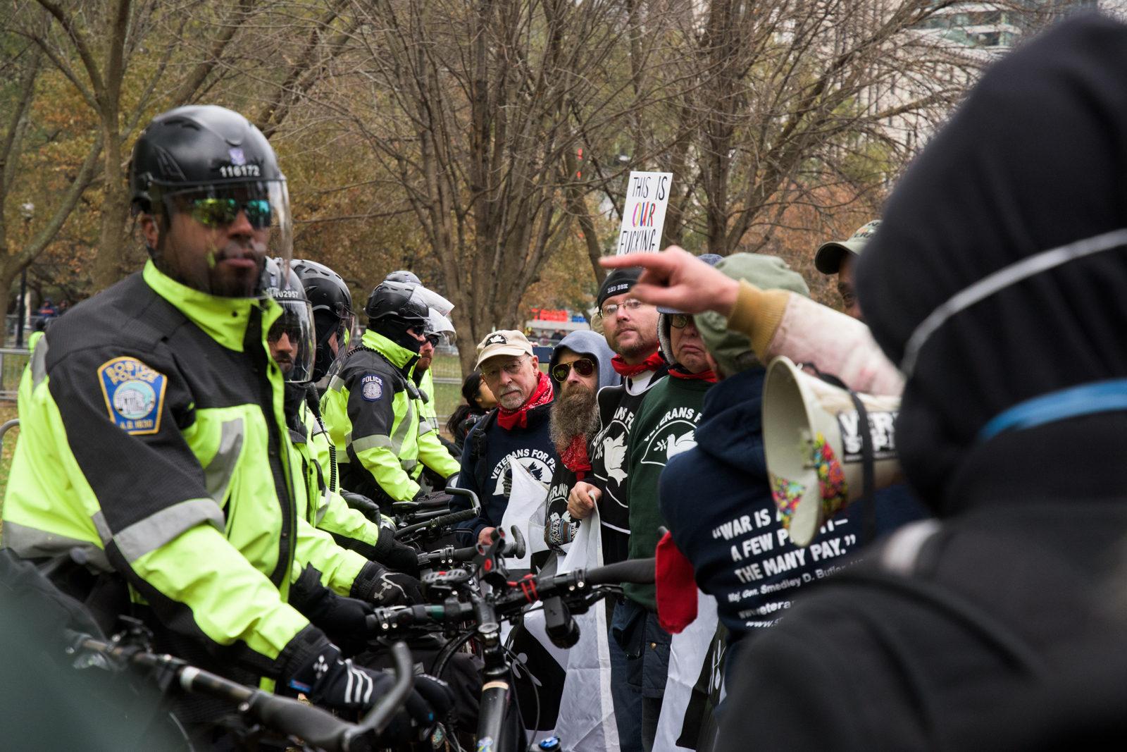 Police barricade an exit out of the Boston Common while Rally for the Republic demonstrators leave the park at the end of the protest. Counterprotesters yell "Who do you serve, who do you protect?" at the police officers. PHOTO BY CHLOE GRINBERG/ DAILY FREE PRESS STAFF