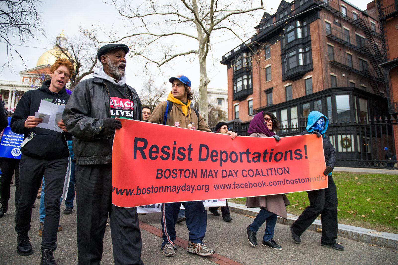 Protesters march at the Resist Deportation! Save TPS! rally outside the Massachusetts State House Saturday afternoon. PHOTO BY CHLOE GRINBERG/ DAILY FREE PRESS STAFF